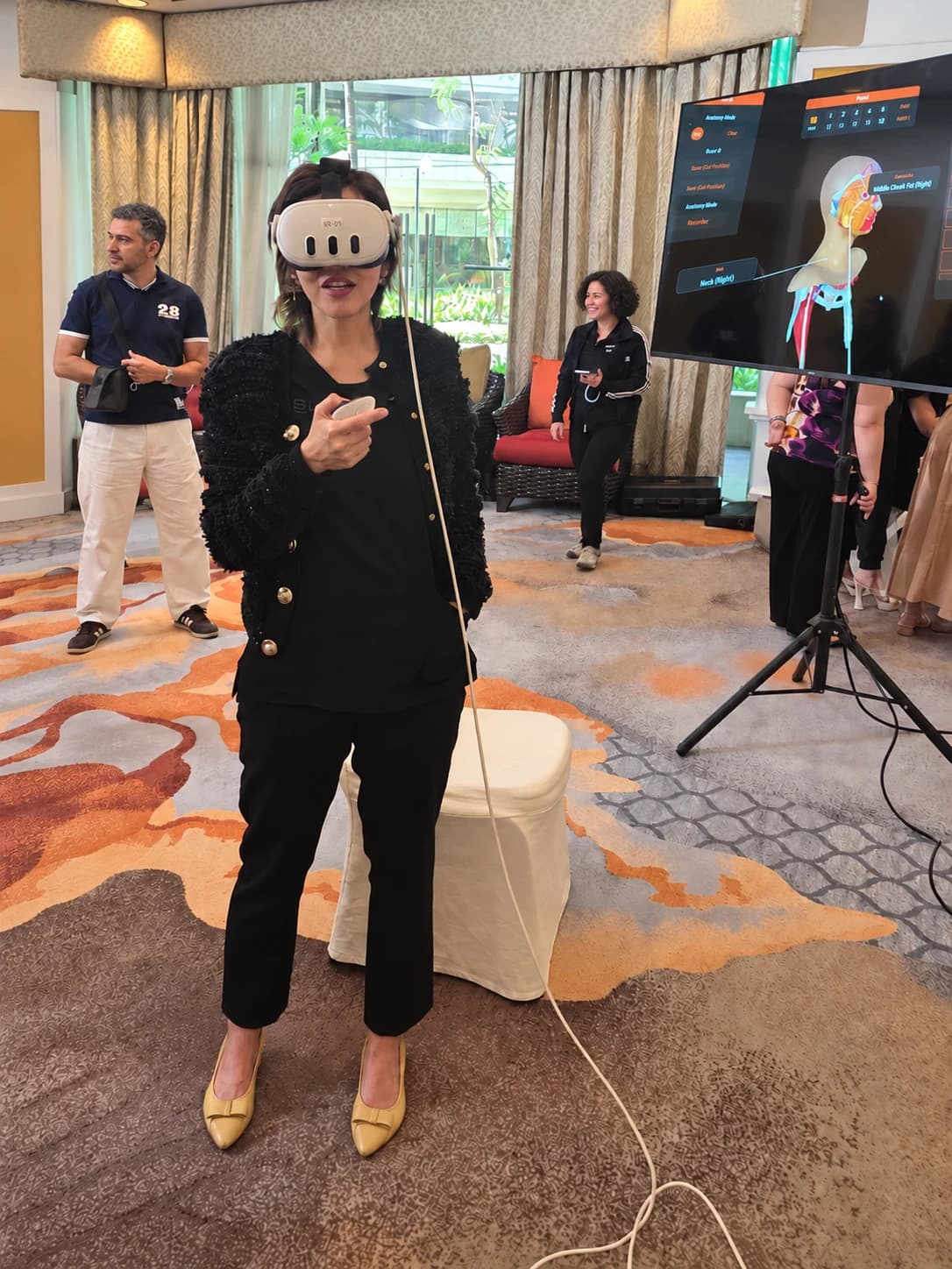 Privacy-edited workshop photo of a participant using FAesthetics VR, with the anatomy view displayed on a monitor